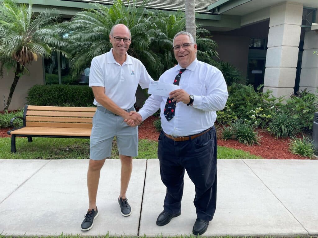 Two men shaking hands and posing for a picture