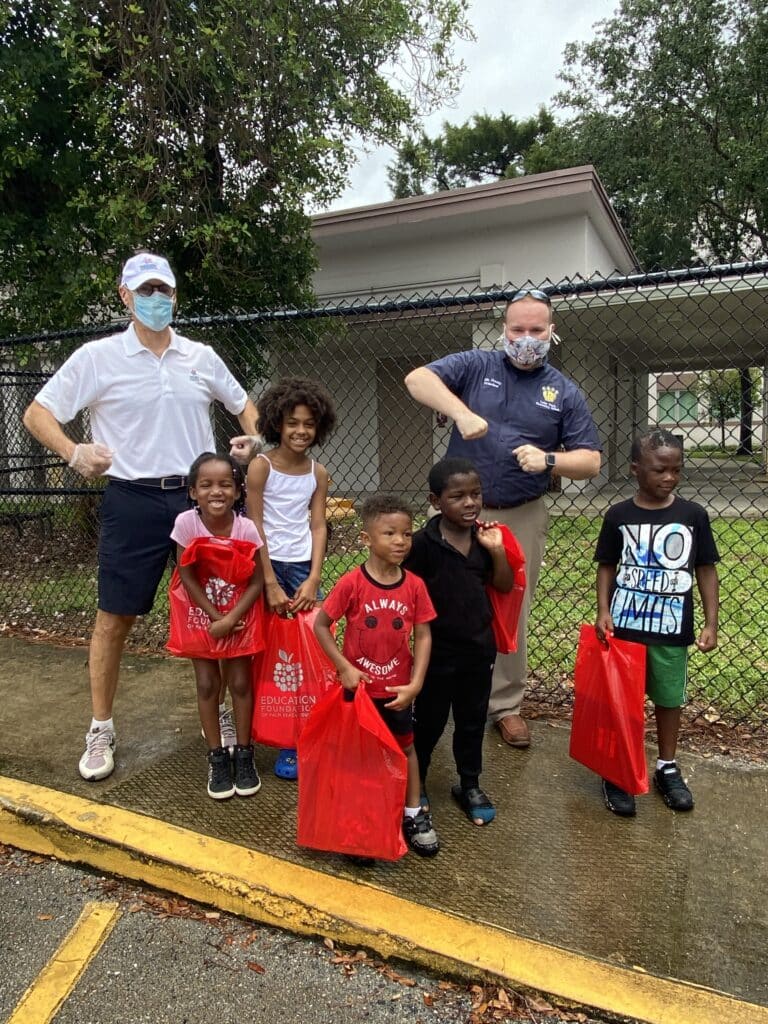 volunteers and kids standing on a sidewalk