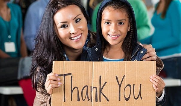 mom and daughter holding thank you sign